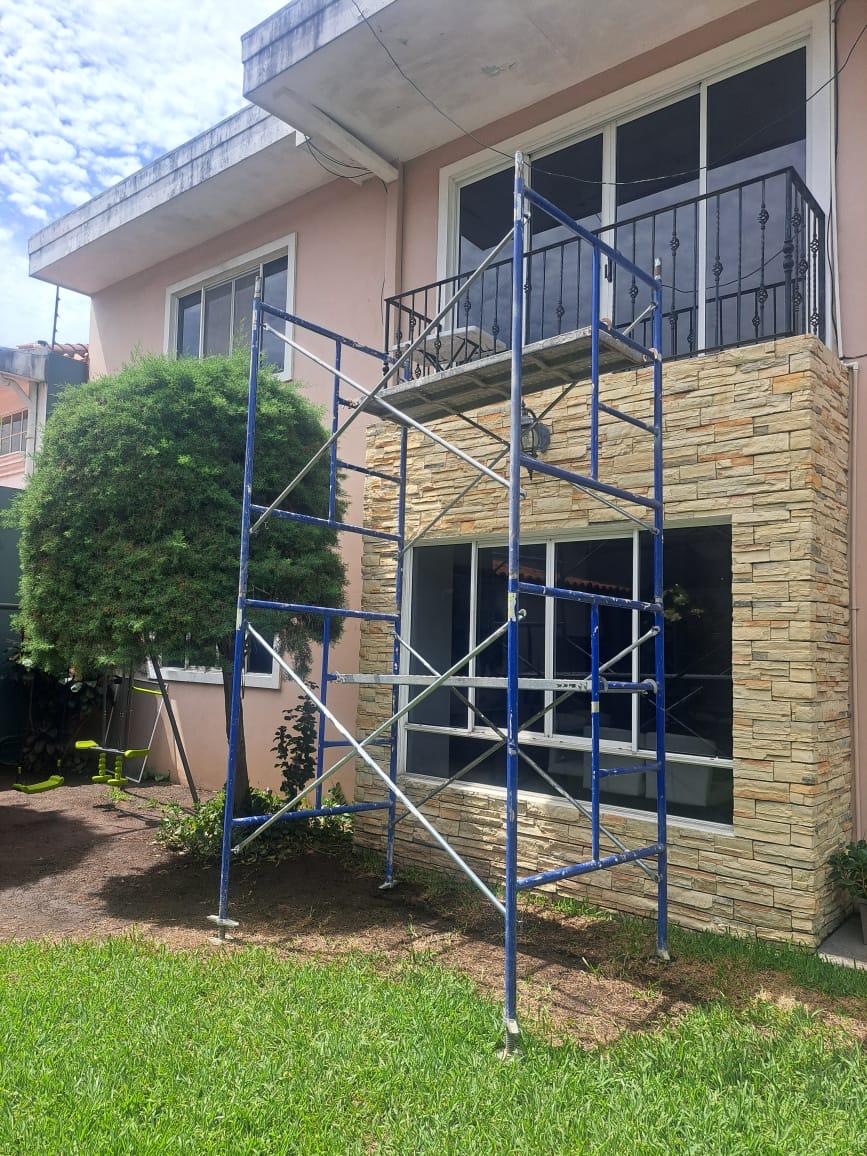 Andamio azul instalado frente a una vivienda